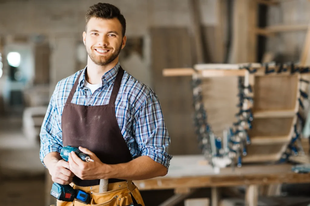 Ein Handwerker in einer Werkstatt mit einem Schraubendreher in der Hand