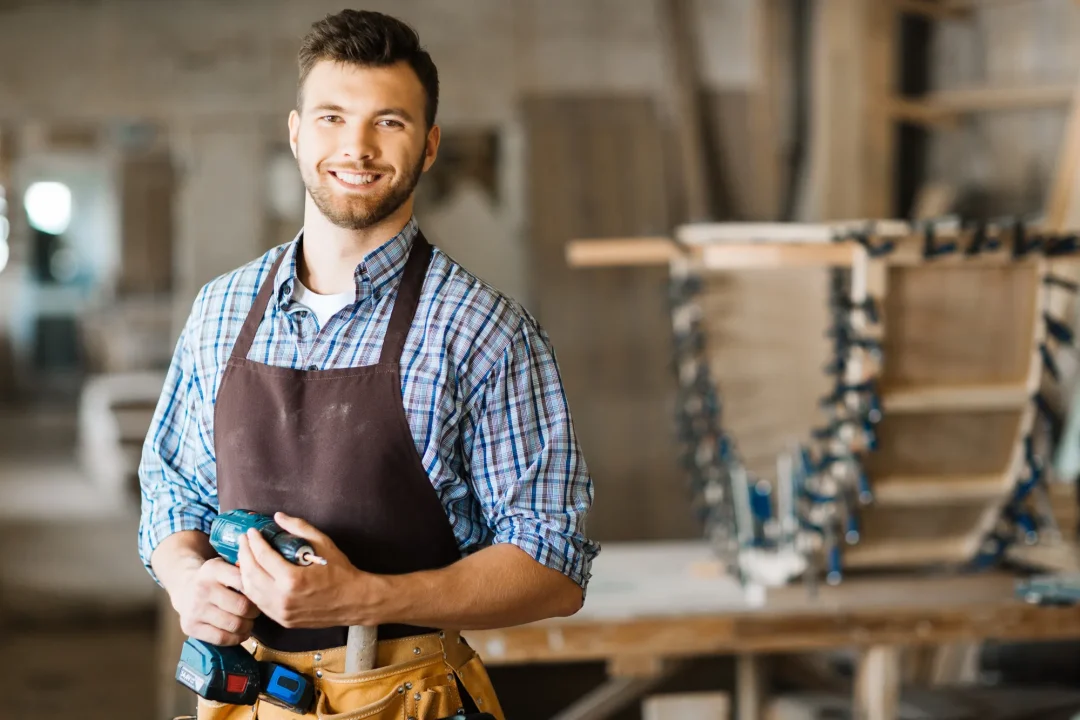 Ein Handwerker in einer Werkstatt mit einem Schraubendreher in der Hand