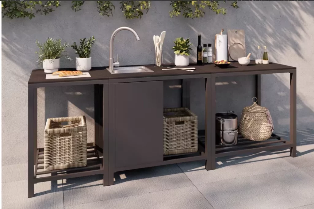 Garten gestalten mit eleganter Outdoor-Küche aus Metall und Holzoptik, integriertem Spülbecken, Arbeitsfläche, Pflanzen, Küchenutensilien und Körben als Stauraum.