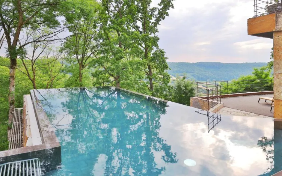 Rooftop-Infinity-Pool im Mawell Resort Langenburg mit Blick über Baumkronen ins Jagsttal