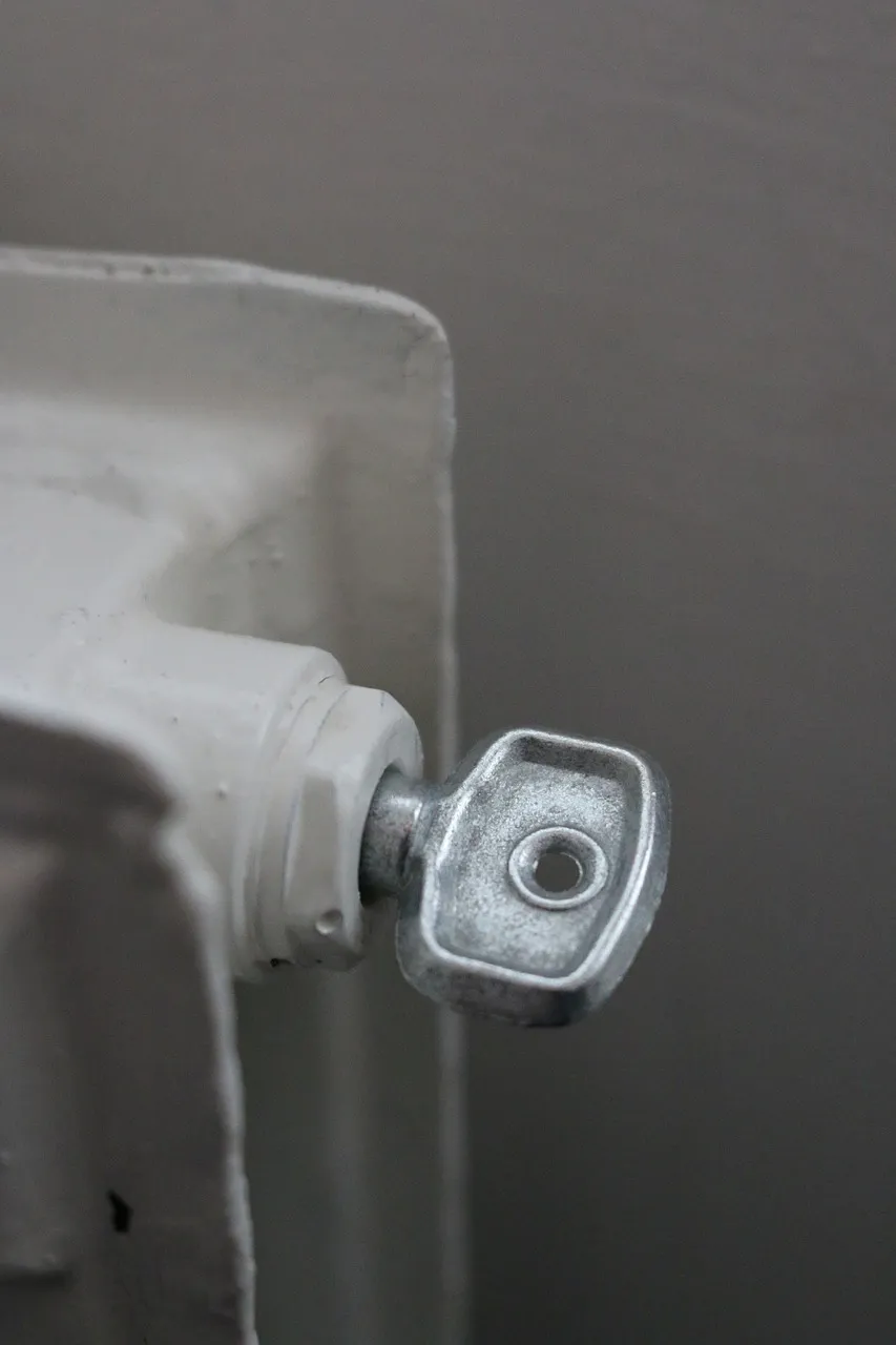 „Entlüftungsventil eines Heizkörpers mit eingesetztem Entlüftungsschlüssel – Vorbereitung zum Heizung entlüften.