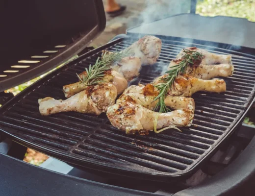 Ein Gas-Tischgrill mit Hähnchenbeinen und Rosmarin