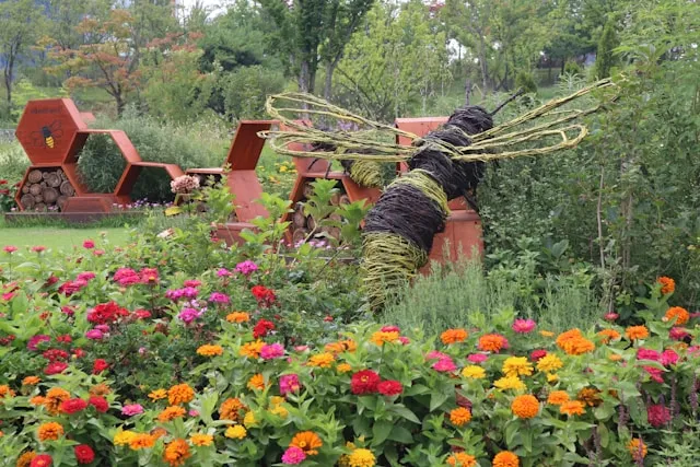 Insektenfreundlicher Garten mit bunten Blumen und Insektenhotel aus Holz